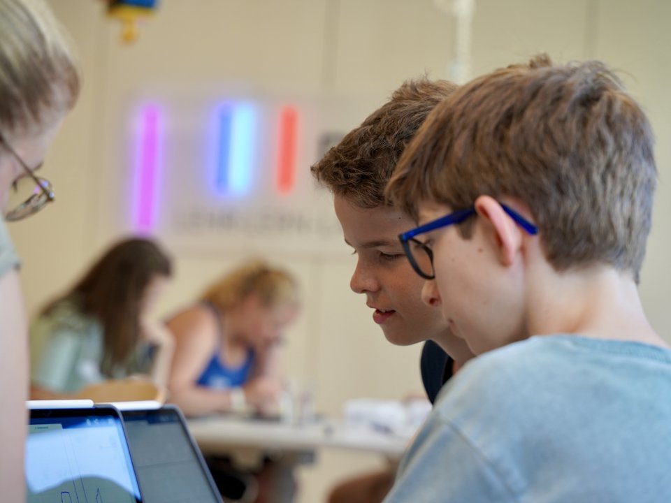 Zwei Schüler schauen auf einen Laptop