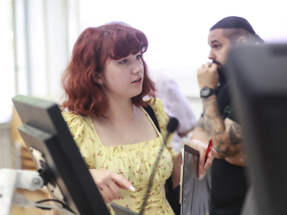 Eine Studierende spricht mit einem Dozenten