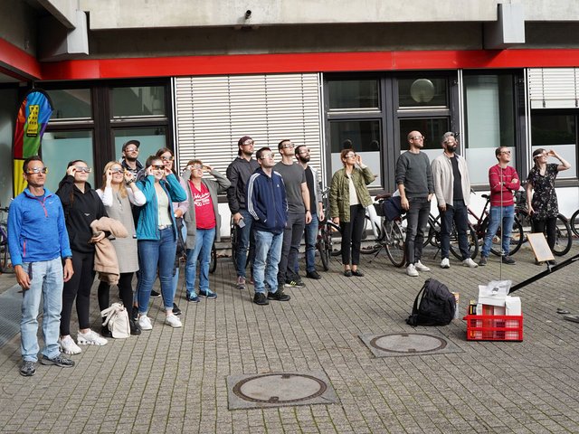 Studierende und Lehrende beim gemeinsamen Beobachten der Sonnenfinsternis im Hof der PHKA.