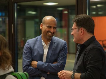 Zwei Männer unterhalten sich, sie lachen.