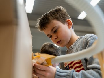 Ein Junge arbeitet konzentriert an einem Werkstück im LLL Technik