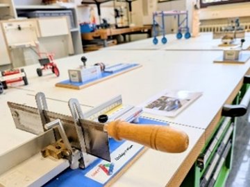 Werkbank mit Säge und Werkzeugen.