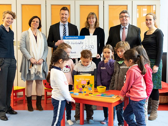 Spendenübergabe in der MiniMa-Werkstatt: BBBank-Regionaldirektor Benjamin Burger (3.v.l.), Prof. Dr. Christiane Benz (4.v.l.), Johanna Zöllner (2.v.l.) und Prof. Dr. Klaus Peter Rippe (2.v.r.). Außerdem Mädchen und Jungen der Kita „Haus  für Kinder“ in Landau. Foto: Tilman Binz / Pädagogische Hochschule Karlsruhe