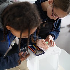 Zu sehen sind Schülerinnen, die eine Sonde bauen.