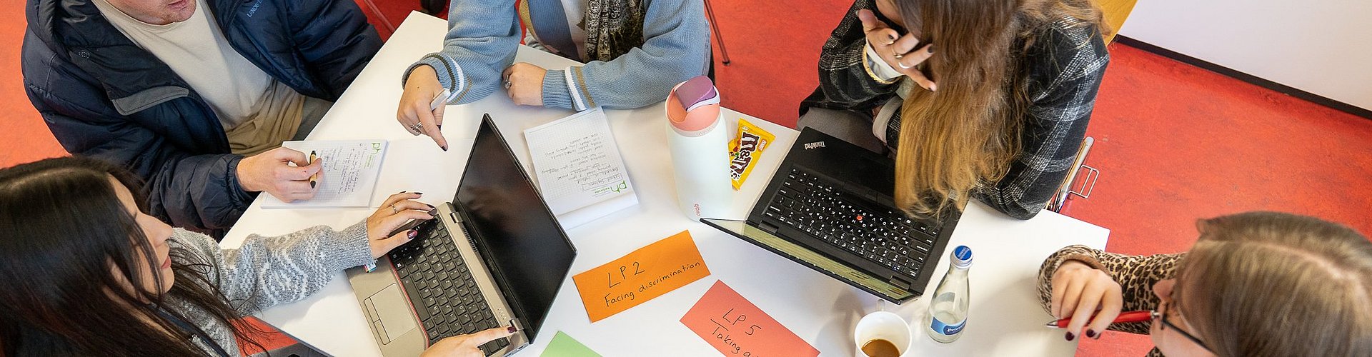 Studierende arbeiten in einem Workshop in einer Gruppe zusammen