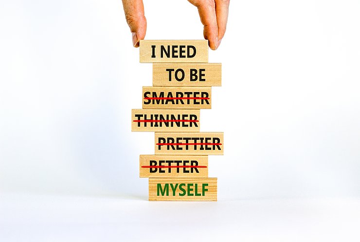 Be myself symbol. Businessman hand. Wooden blocks with words 'i need to be myself, not smarter, thinner, prettier, better'. Beautiful white background, copy space. Psychological, be myself concept. Be myself symbol. Businessman hand. Wooden blocks with words 'i need to be myself, not smarter, thinner, prettier, better'. Beautiful white background, copy space. Psychological, be myself concept.
