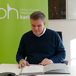 Prof. Dr. Christian Gleser, Prorektor der Pädagogischen Hochschule Karlsruhe, beim Unterschreiben der Abschlusszeugnisse 2021. Foto: Roxane Fijean/PHKA