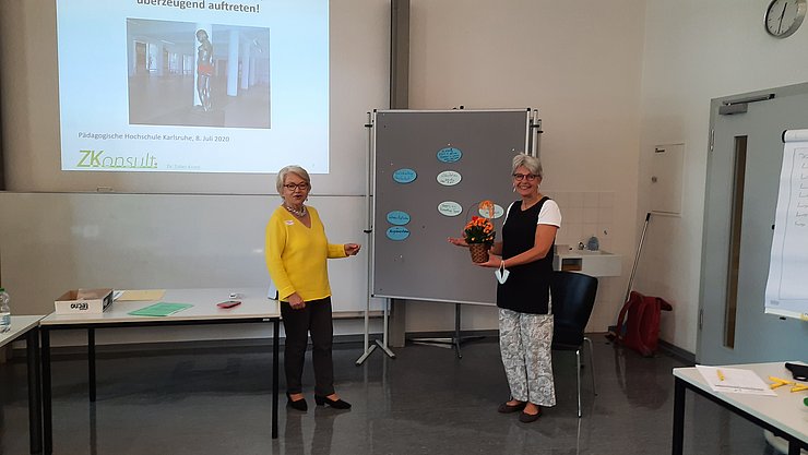 Referentin Elisabeth Zuber Knost und GB Britta Nann beim Workshop im Juli Referentin Elisabeth Zuber Knost und GB Britta Nann vor im Seminarraum vor der Leinwand beim Workshop im Juli 2020. Frau Nann überreicht der Referentin Blumen. Der Sichwerheitsabstand ist eingehalten.