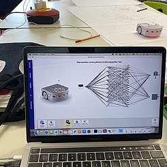 Hier sieht man einen Thymio-Roboter, der mithilfe eines neuronalen Netztes programmiert wird.